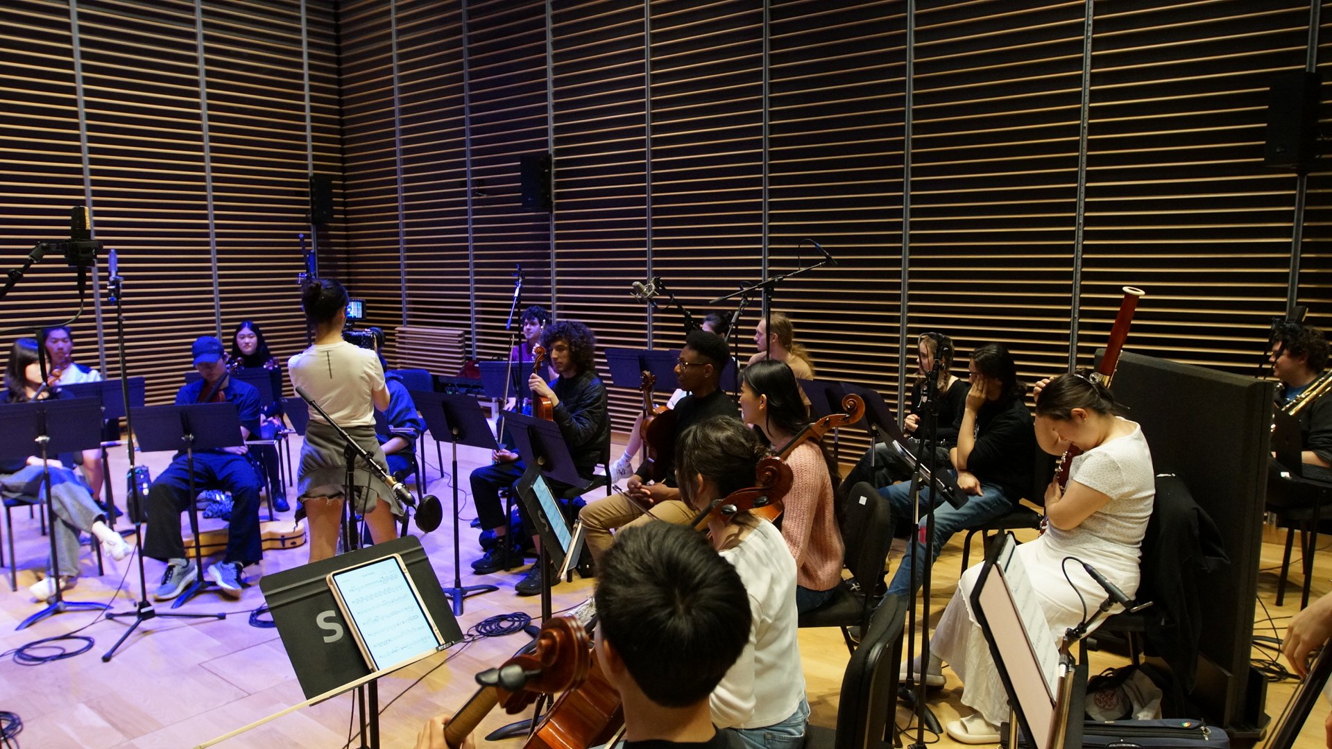 A large ensemble gathered in a recording studio for an orchestral scoring session